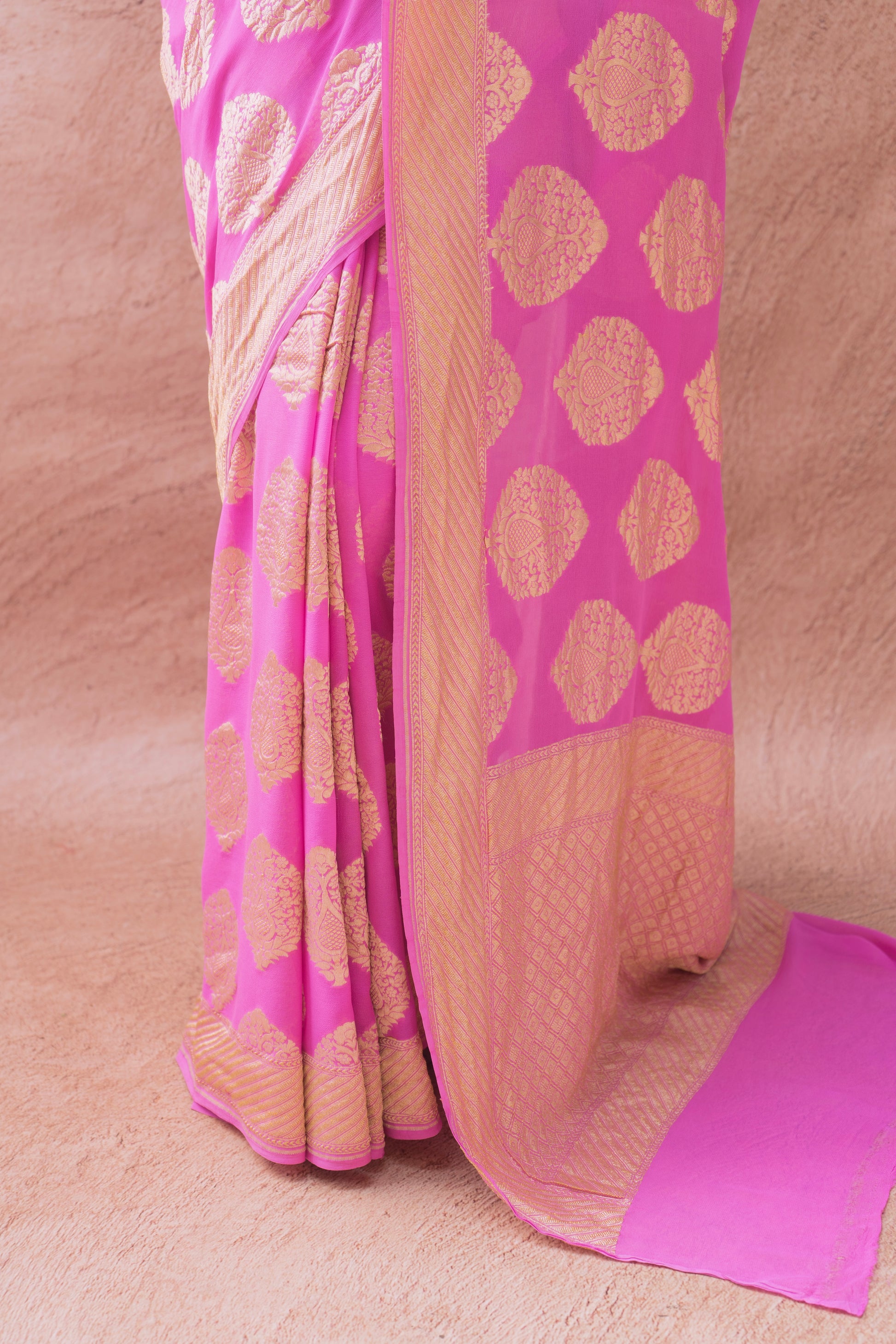 Pink Banarasi elegance with rich gold motifs, beautifully worn against a neutral backdrop