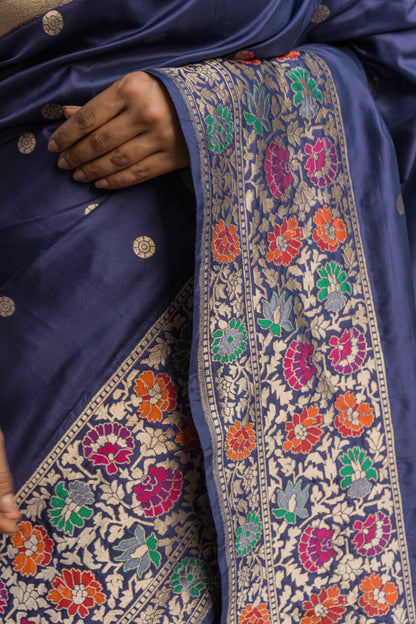 Blue Banarasi elegance with floral motifs and rich zari borders, styled with a vibrant pink blouse piece.