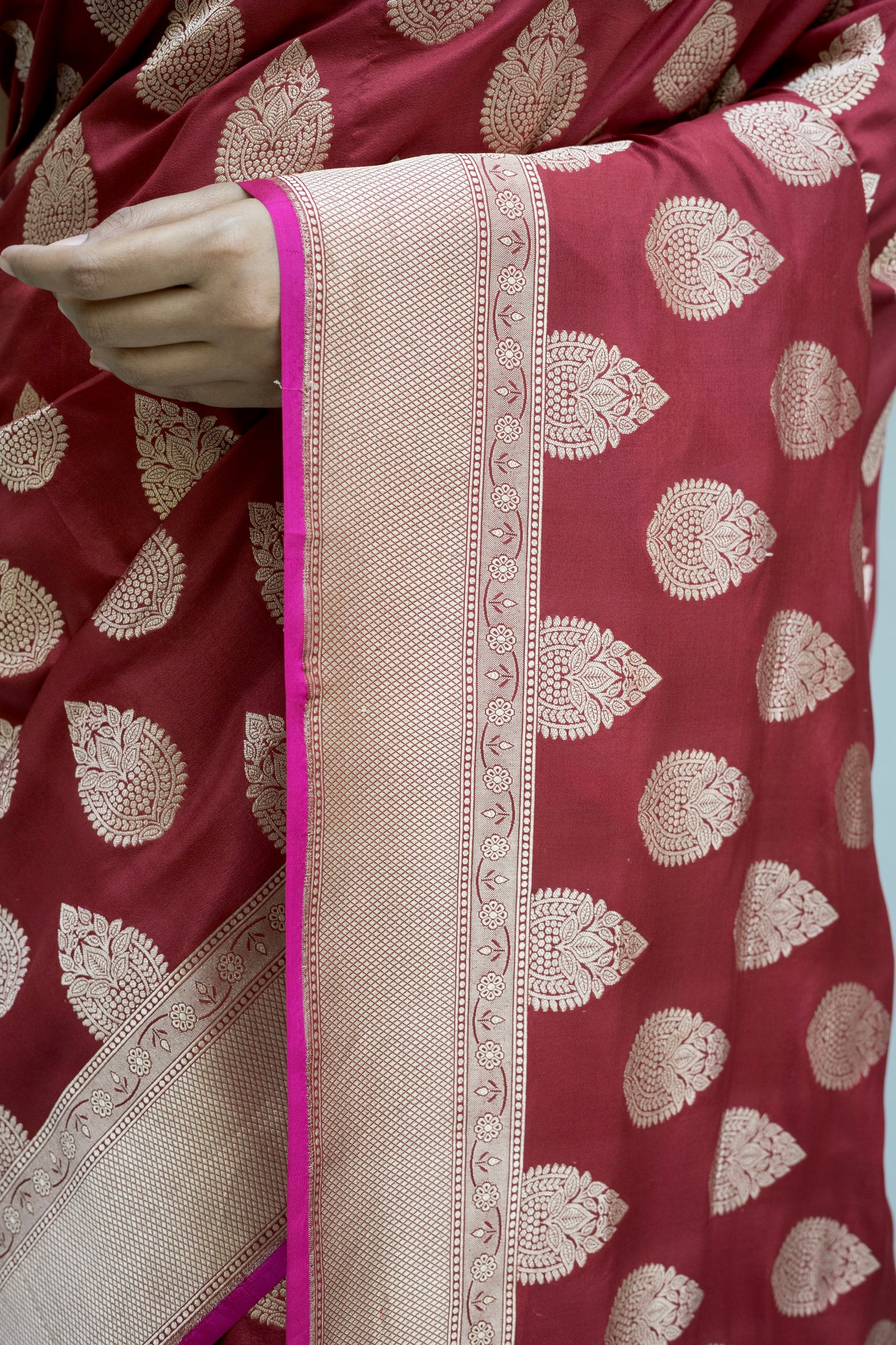 Maroon Banarasi richness with crisp white patterns, captured on a calm grey setting