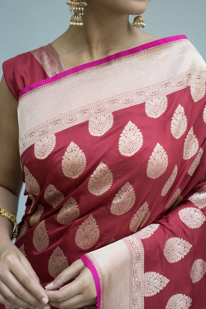 A perfect blend of culture and style—maroon Banarasi saree with white accents on a grey backdrop