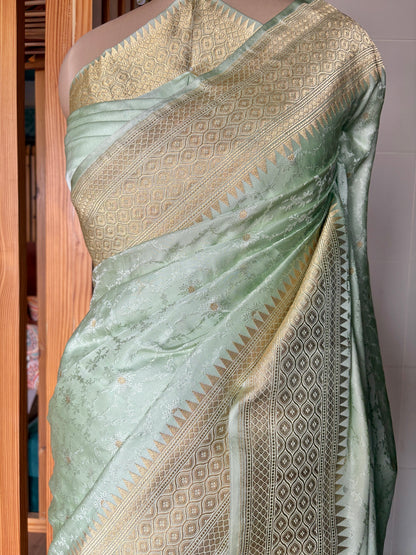 The charm of a light green Banarasi saree with gold accents, highlighted on a mannequin against a clean neutral backdrop