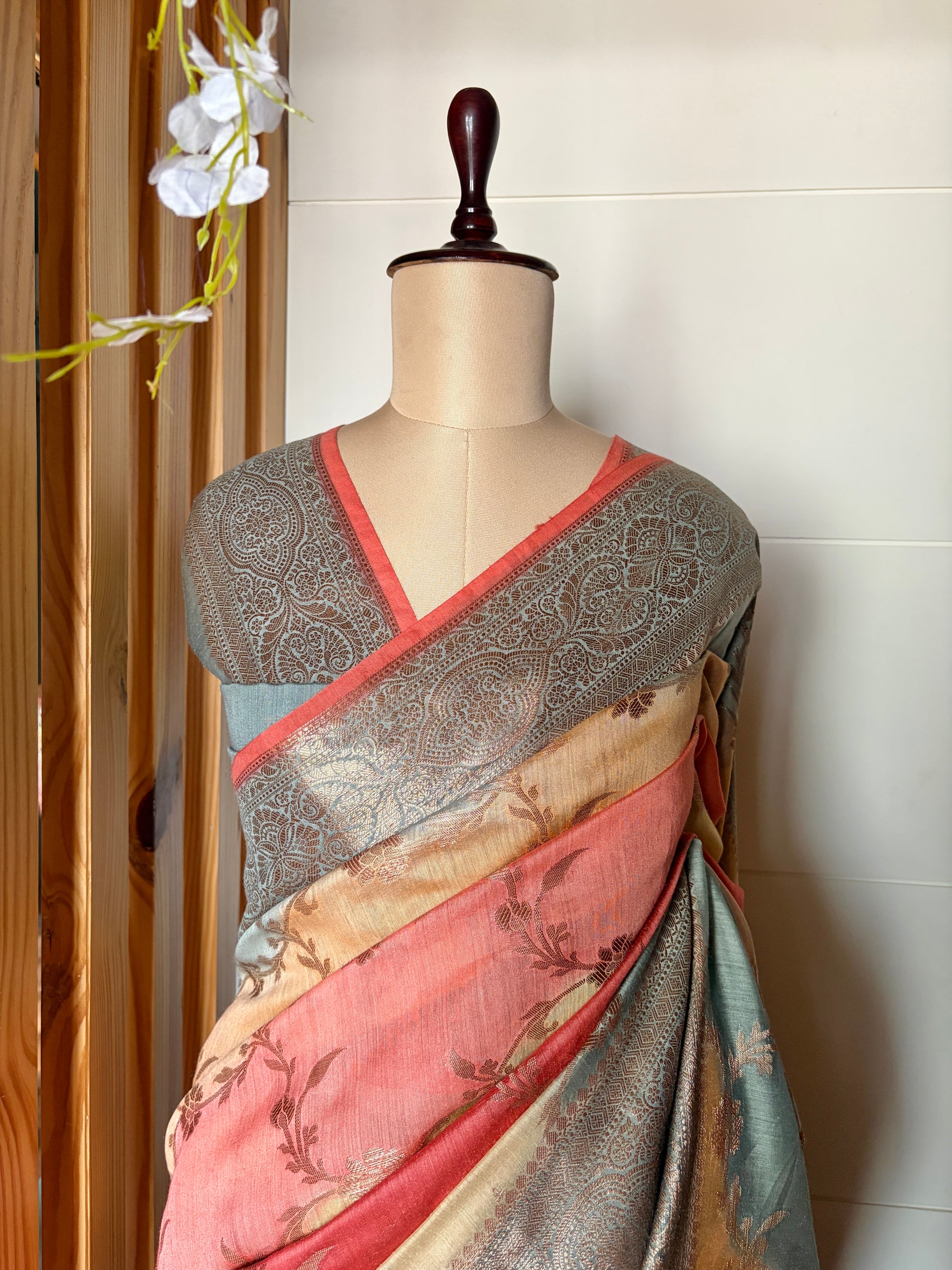 Mannequin wearing a floral design luxury Banarasi saree against a clean white wall