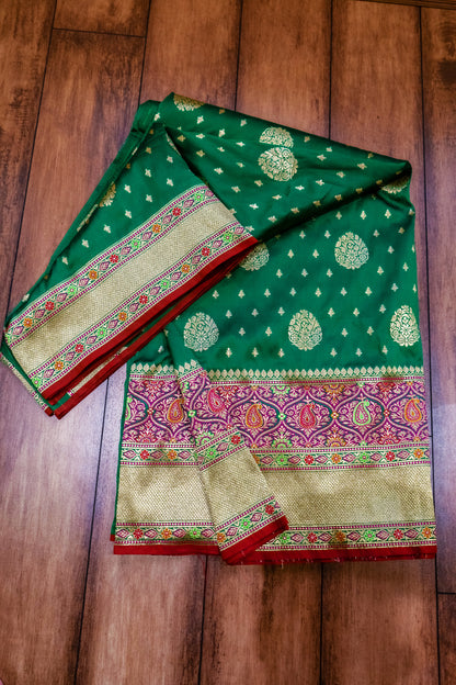 A rich green Banarasi saree adorned with a striking red border for a timeless traditional look