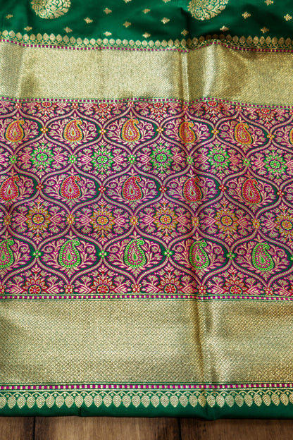 A classic green Banarasi saree with a vibrant red border that radiates festive charm