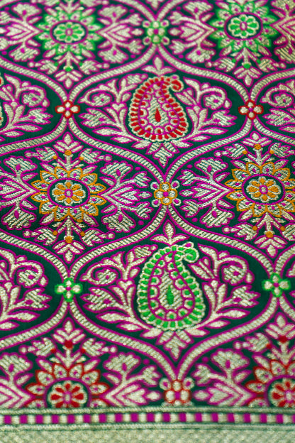 Green Banarasi beauty paired with a contrasting red border for pure traditional grace