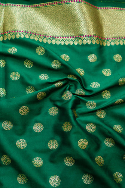 A stunning green Banarasi saree featuring a regal red border woven with heritage artistry