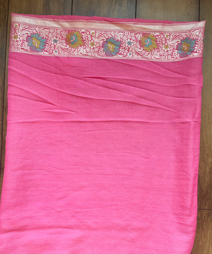 A woman in a light pink Banarasi saree highlighted by fine zari patterns, capturing effortless traditional elegance.