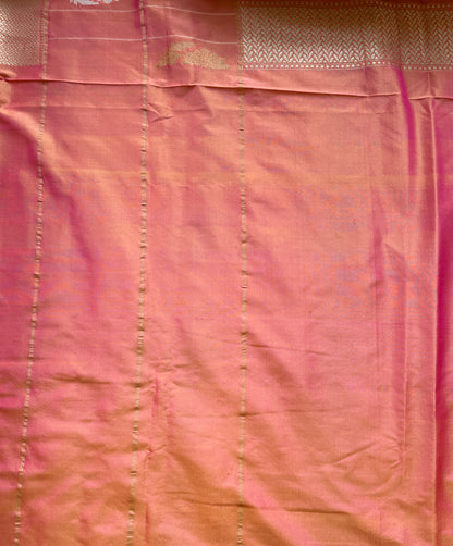 A woman wearing a light green Banarasi saree with rich weaving and subtle golden detailing.