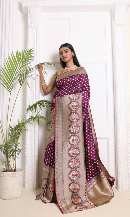 A stunning purple Banarasi saree featuring silver and gold patterns, intricate zari artistry, paired with a red blouse piece