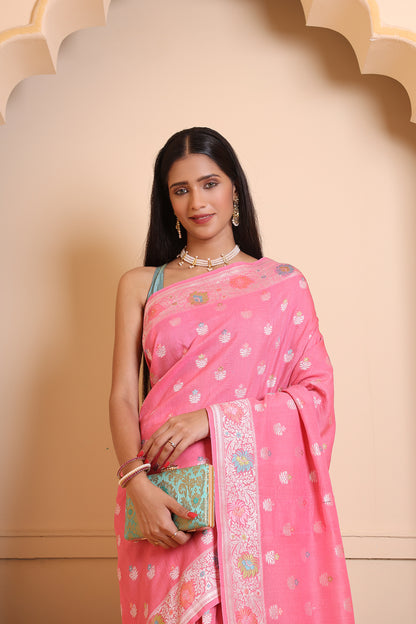 A woman draped in a light pink Banarasi saree adorned with delicate zari weaving for an elegant, timeless look.