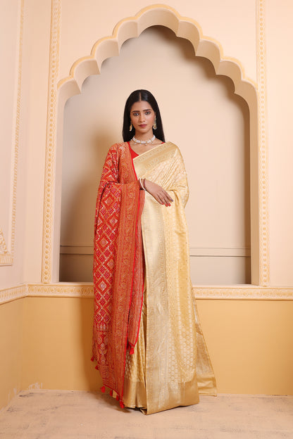 A light cream Banarasi saree with delicate zari motifs, blending subtle elegance with traditional charm.
