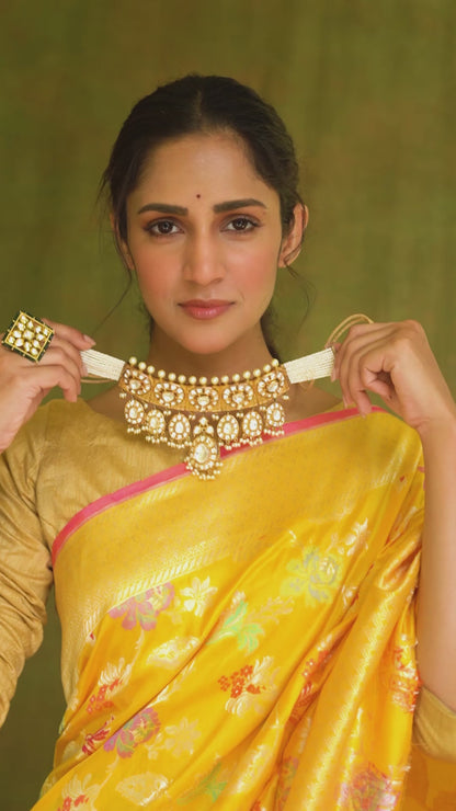 Elegance defined in a yellow Katan Multi-Meena Banarasi saree featuring floral patterns, zari detailing, and a solid blouse piece.