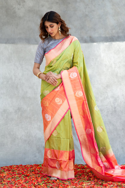 A woman draped in a light green Banarasi saree adorned with delicate zari work for a fresh, elegant look.