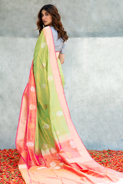 A light green Banarasi saree featuring intricate zari motifs, radiating soft charm and traditional beauty.